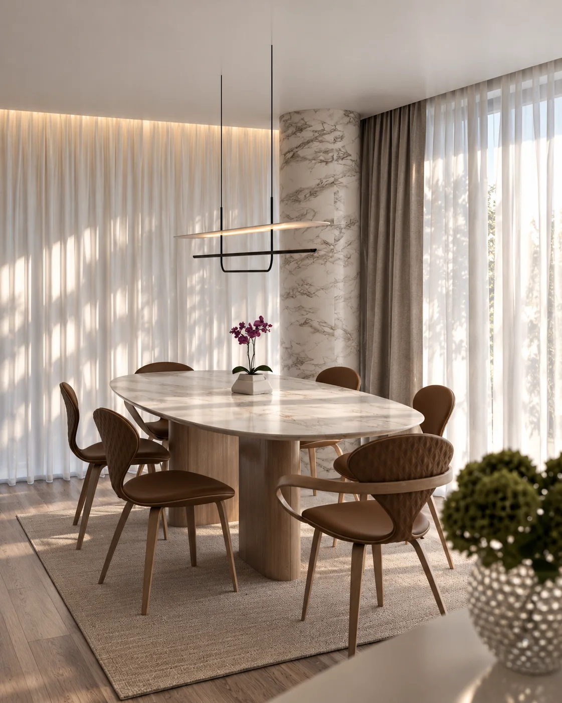 Sala de jantar do projeto Entrelaço, com mesa oval de mármore Matarazzo, cadeiras de madeira, luminária suspensa e cortinas translúcidas iluminadas pelo sol.