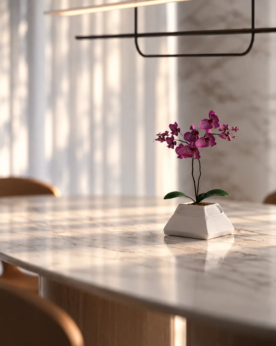 Detalhe de uma orquídea de flores rosadas sobre a mesa de mármore Matarazzo do projeto Entrelaço, com iluminação natural e fundo desfocado.